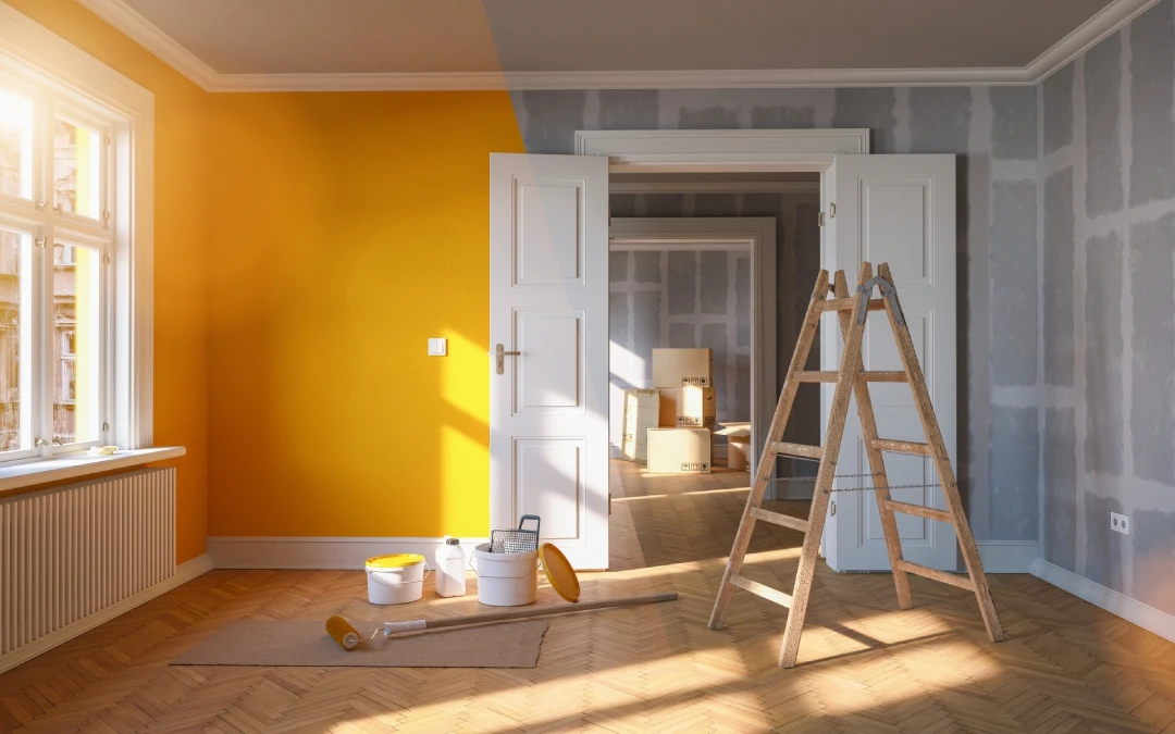 A room in the process of being painted, with one wall painted yellow and other walls in primer. A ladder, paint cans, and painting tools are placed on a wooden floor with sunlight streaming through a window—an ideal snapshot for any painting portfolio.